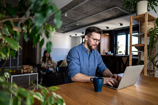istock Father working from home while wife and child play in background 2223995849