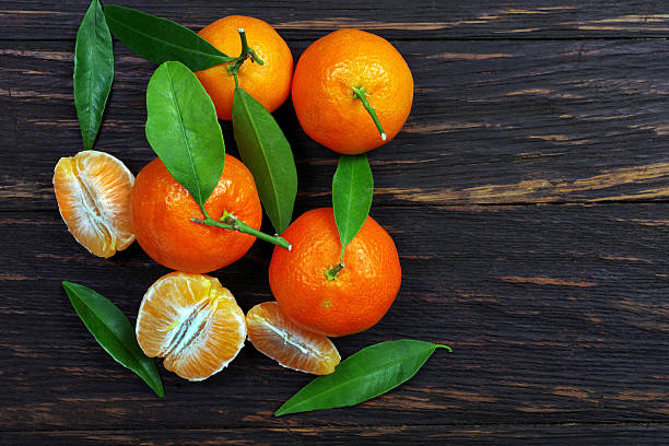 istock bright ripe tangerines on a wooden table. copy space 2223998378