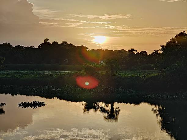 istock Tranquil sunset over a reflective lake surrounded by verdant forest scenery 2223999767