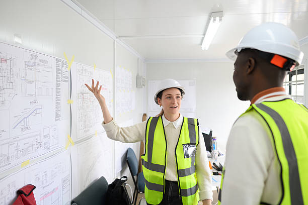 istock Builder Presenting Construction Designs to Colleague in an Office 2224001563