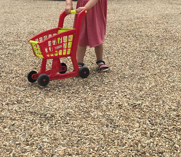 Leg view of small toddler child playing with toy cart