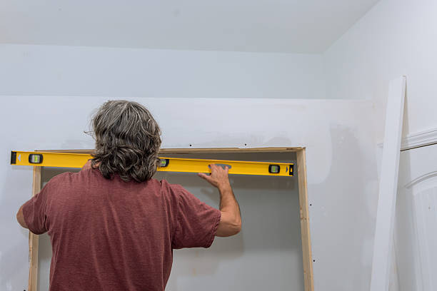 istock Man uses level to ensure accuracy while assembling wooden frame in home renovation project 2224005458