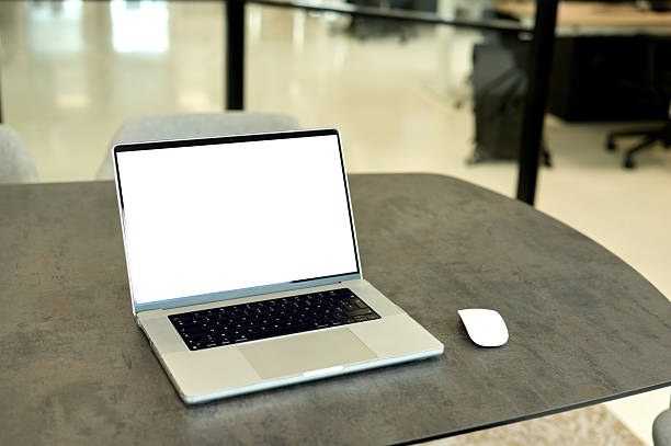 Modern laptop showing blank screen on office desk with a mouse next to it, ready for work