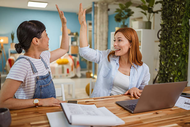 istock Multicultural female friends high five for support at home office 2224011161