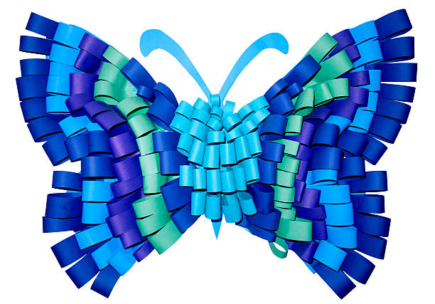 Rolled strips of vibrant blue, teal, and purple paper create a textured and layered butterfly, showcasing creativity and intricate craftsmanship against a clean white backdrop