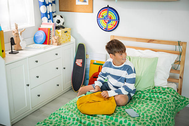 Teenage boy packing for school at his room
