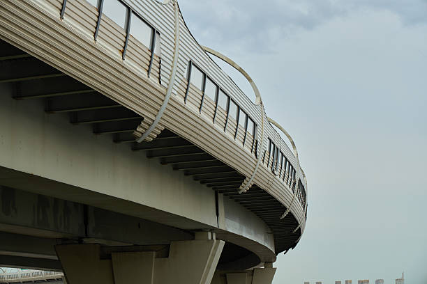 A sleek elevated railway structure curving gracefully against a moody sky, showcasing modern design.
