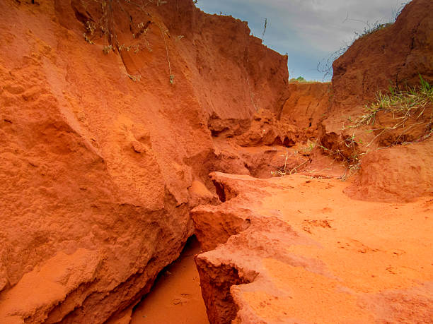 Muine Red Canyon landscape with layered red sandstone formations and clear sky. Erosion, geology, desert, Vietnam, natural texture, arid terrain, rock layers of Muine red canyon in Vietnam