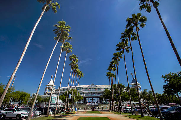Hammond Stadium at Lee Health Sports Complex, Fort Myers, Lee County, Florida, spring training home of the Minnesota Twins baseball team.  Palm trees lining the wide walkway towards the front of the stadium, clear blue sky.  Photo taken March 20, 2024 before a Twins spring training game.