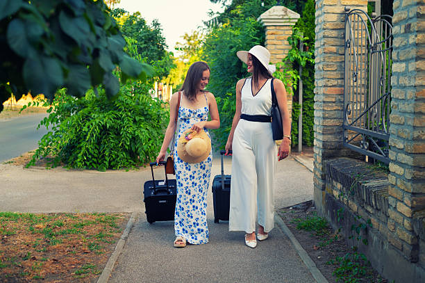 Two young happy women on vacation arrived on destination.