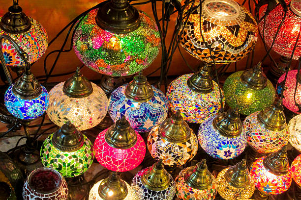 Colorful Turkish mosaic lamps hanging together. Stained glass patterns in red yellow blue green. Traditional decorative lighting, close-up view, ornamental design illuminated Arabic style lanterns