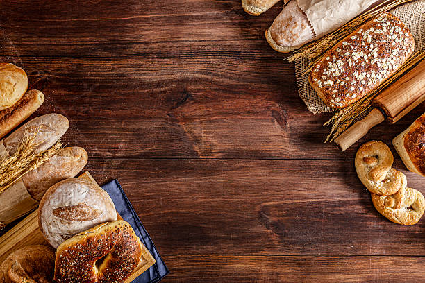 istock Assortment of bread making a frame on rustic wooden table with copy space 2224025479
