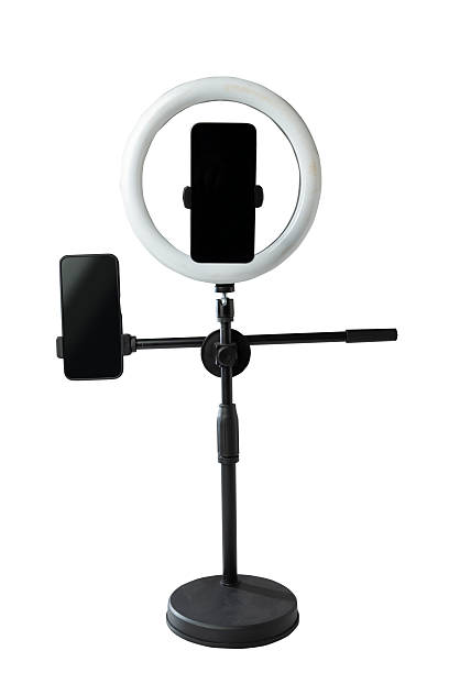istock Round LED ring light with a cellphone on a phone holder isolated over a white background. Vlogging or live streaming equipment. Mockup or Copy space 2224030331