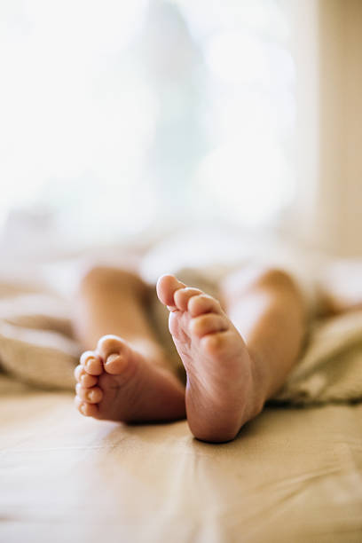 Closeup shot of the feet of an Asian Indian infant fast asleep at home.