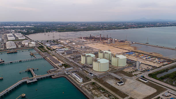 istock LNG storage tanks and terminal facility at dusk, showcasing large cylindrical containers, offshore piers, and cargo ships. Industrial landscape representing global liquefied natural gas 2224034351