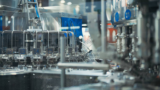 istock precision bottling equipment with transparent liquid containers high capacity bottle filling and capping machine in industrial automation line with synchronized multi-step process  packaging system 2224035485