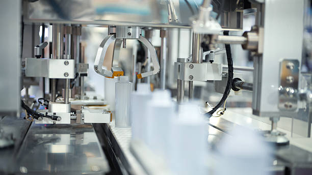 istock pharmaceutical or cosmetic production line with automated dispenser for small plastic bottles | precision liquid filling system in modern industrial packaging machine 2224035486