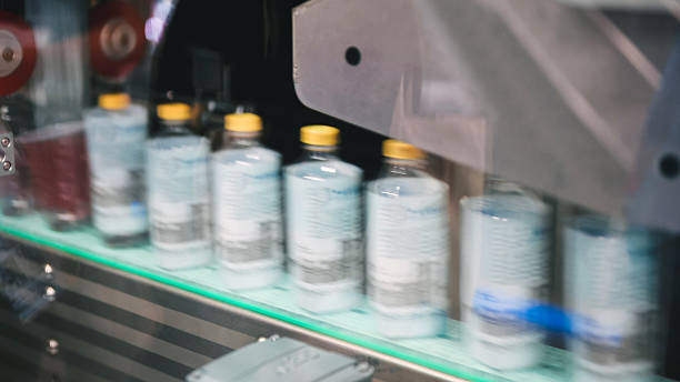 istock Automation drinking and packaging technology high-speed filling and capping line with clear plastic bottles in beverage or chemical production | automated liquid packaging line in industrial factory 2224035502