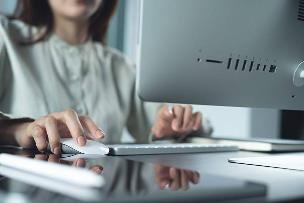 istock Business woman working on desktop computer, hand clicking on computer mouse with digital tablet on office table. Businesswoman online working, surfing the internet from home office, remote work, closeup 2224038505