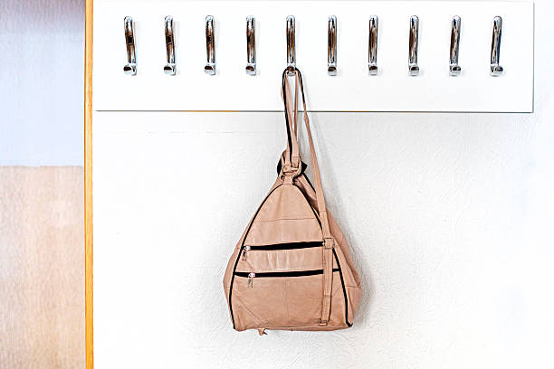 istock light leather backpack hanging on a hanger with metal hooks in a classroom, office. Back to school 2224043319