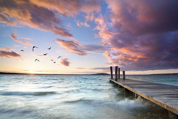 Breathtaking Sunset Glow: Pier Above Gentle Waves