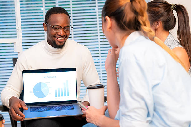 istock Black businessman leads AI tools presentation meeting in office, diverse team collaborates sharing ideas and planning strategy of marketing with AI tool display on laptop, digital transformation. 2224045235