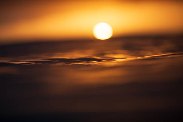 istock A golden sun rising from a dark rippled ocean surface captured from within the water a dawn. 2224046781