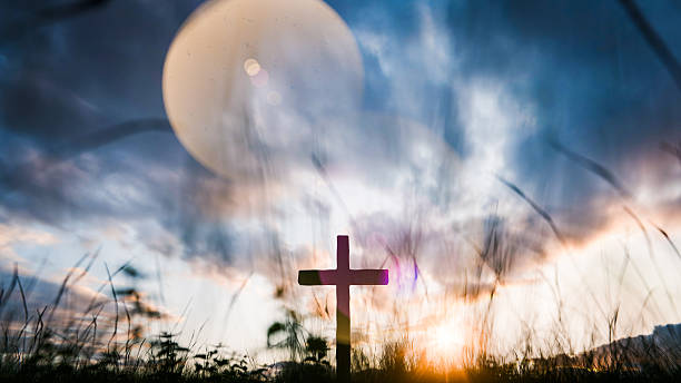istock Christian cross standing at sunset with dramatic sky and lens flare 2224049882