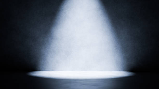 Spotlight illuminating empty stage floor in dark room with grunge wall background