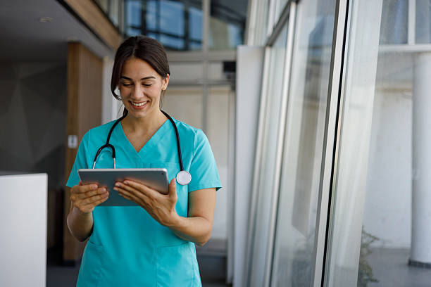 istock Young female doctor smiling while using a digital tablet in a modern hospital setting, embodying professionalism in healthcare 2224051534