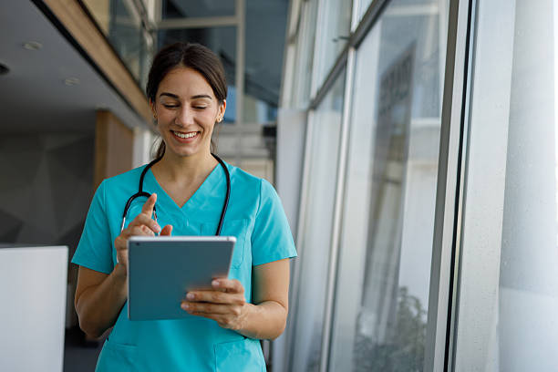 istock Smiling female doctor using a digital tablet, working in a modern hospital corridor 2224052626