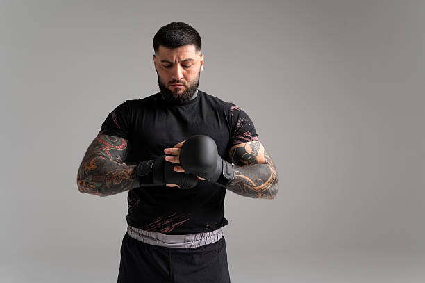 Mma fighter preparing for training, wearing gloves and hand wraps