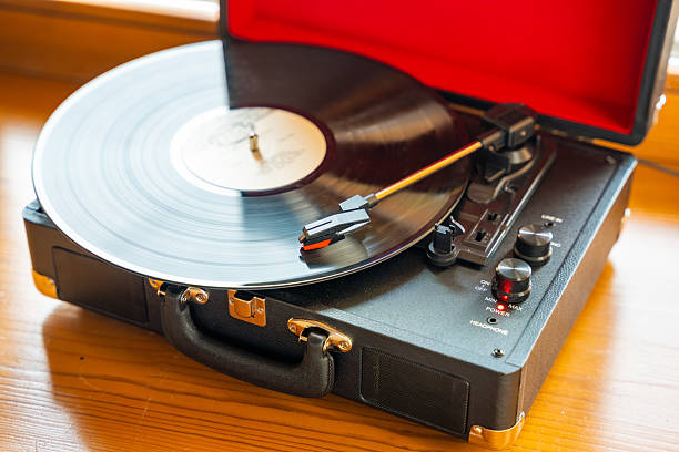 istock Vintage suitcase-style record player spinning vinyl record. Retro music in motion creating nostalgic atmosphere in home interior 2224054526