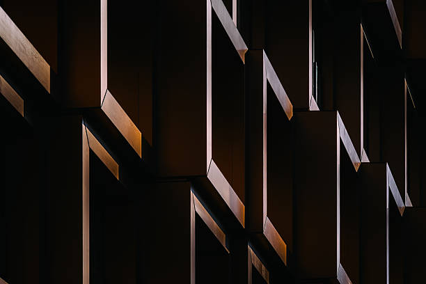 istock Modern residential facade with stacked orange balconies casting strong geometric shadows 2224063937