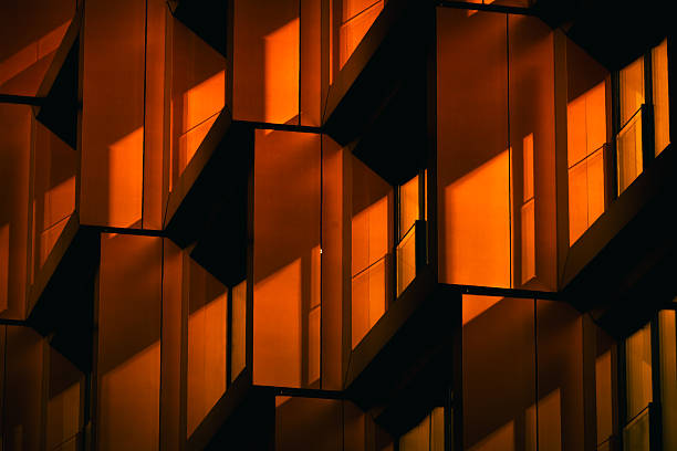 istock Modern residential facade with stacked orange balconies casting strong geometric shadows 2224063938