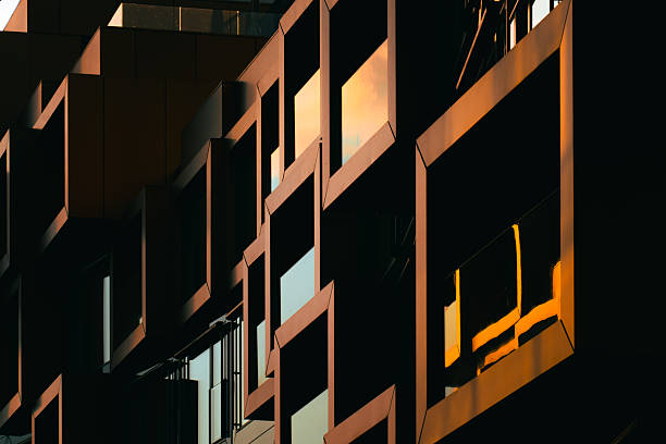istock Modern residential facade with stacked orange balconies casting strong geometric shadows 2224063946