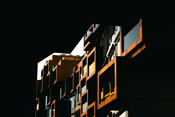 istock Modern residential facade with stacked orange balconies casting strong geometric shadows 2224063948