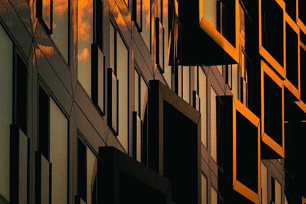 istock Modern residential facade with stacked orange balconies casting strong geometric shadows 2224063949