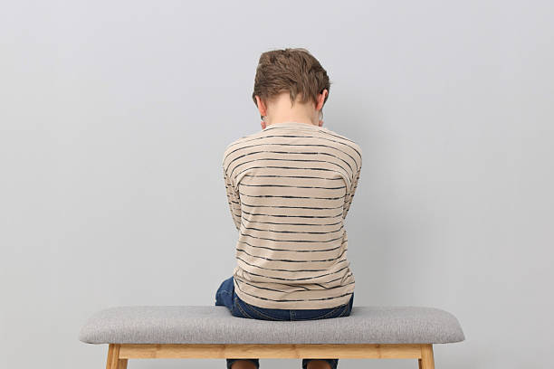 istock Autism concept. Lonely little boy on bench at home, back view 2224066193