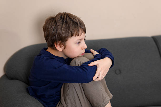 istock Autism concept. Lonely little boy on sofa at home 2224066207