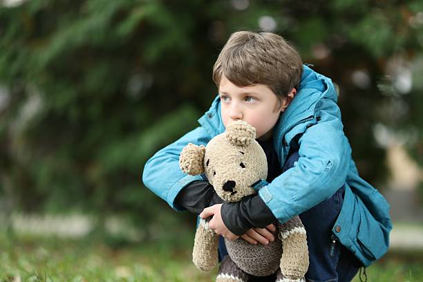 istock Autism concept. Lonely little boy with teddy bear outdoors, space for text 2224066630