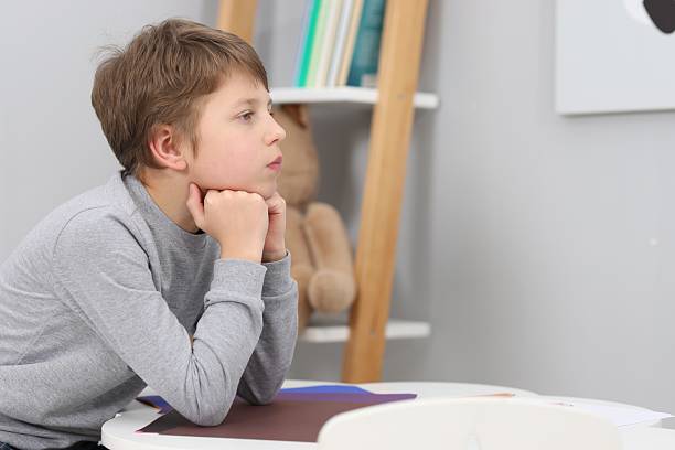 istock Autism concept. Lonely little boy at table indoors, space for text 2224066648