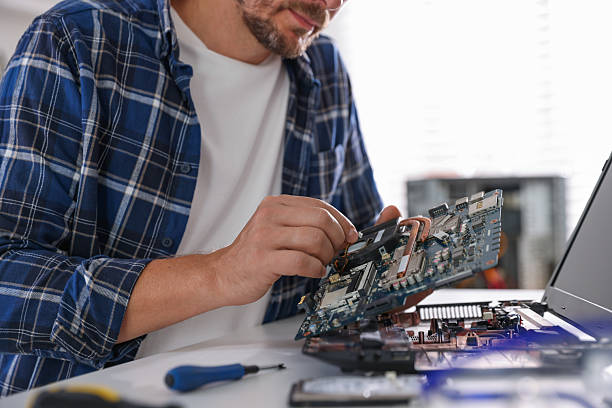 istock Man installing motherboard into laptop at white table, closeup 2224067049