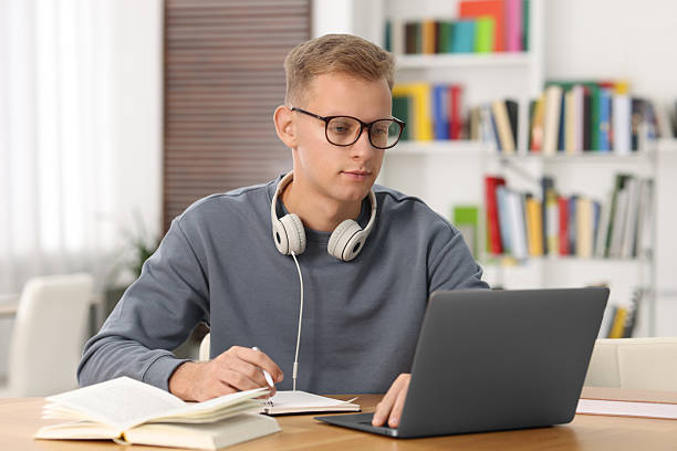 istock Student preparing for exam with laptop at table indoors 2224067366