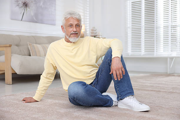 istock Senior man sitting on floor at home 2224068970
