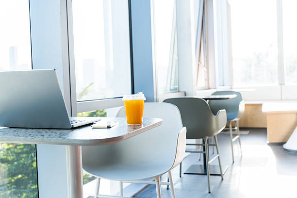 Empty office desk with modern laptop, paperwork contract or letter correspondence on top, glass table comfortable furniture of businessperson or employee in boardroom, interior design concept