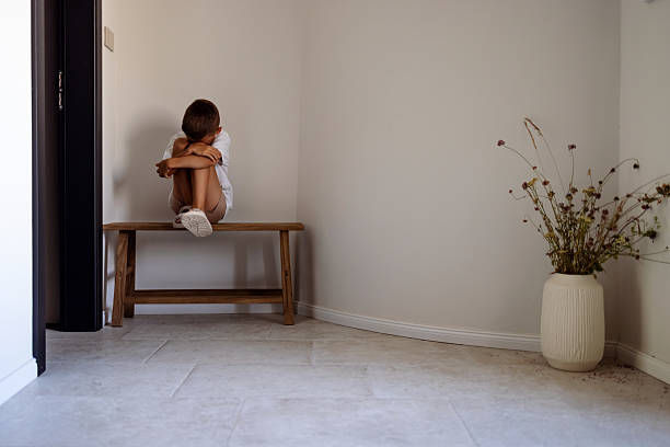Lonely Child Sitting on Bench in Minimalist Interior with Decor