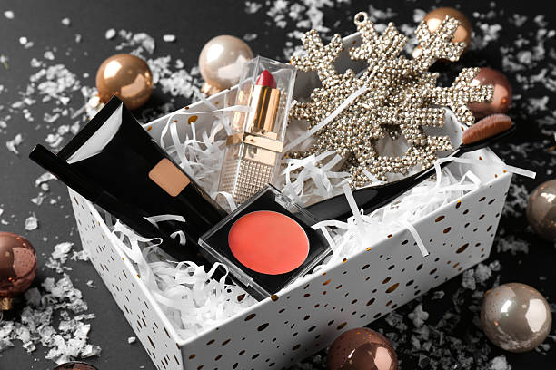 istock Christmas gift box with decorative cosmetics and festive decor on black background, closeup 2224075598