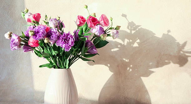 istock Vase with beautiful eustoma flowers near beige wall, closeup. Space for text 2224076541
