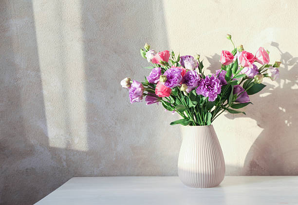 istock Vase with beautiful eustoma flowers on white wooden table, space for text 2224076545